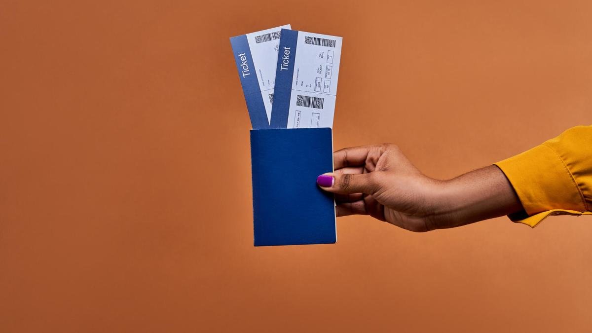 A person holds two plane tickets.