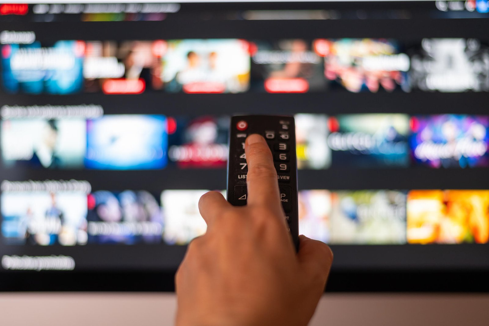 Remote control pointed at a TV with streaming services menu