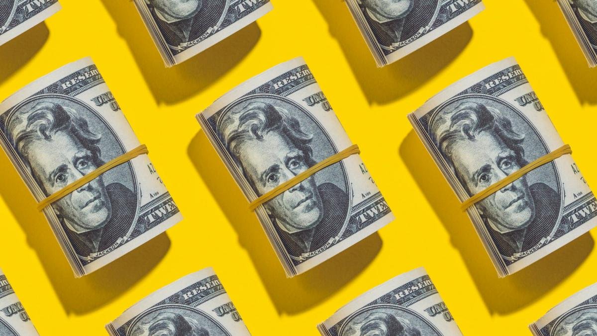 Rolls of $20 bills on a yellow background
