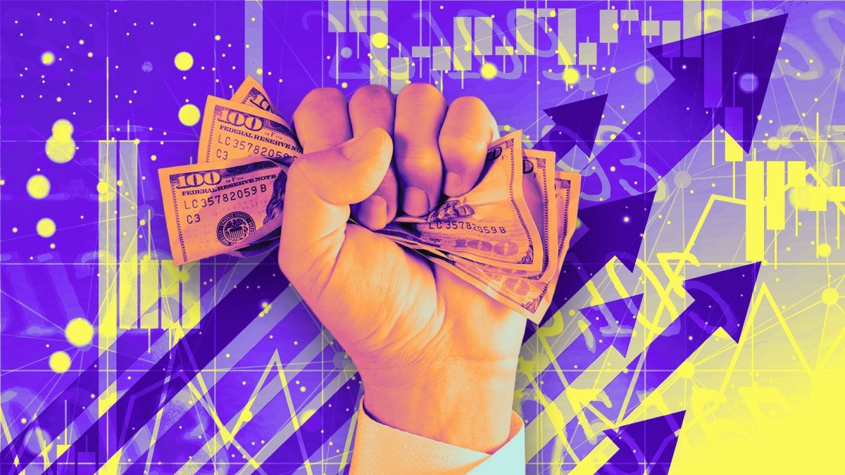 Hand holds cash on chart arrows