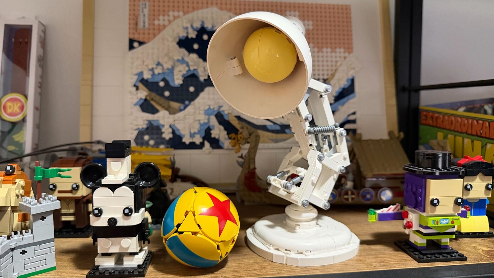 A Lego Pixar Lamp on a shelf amongst other Lego builds.