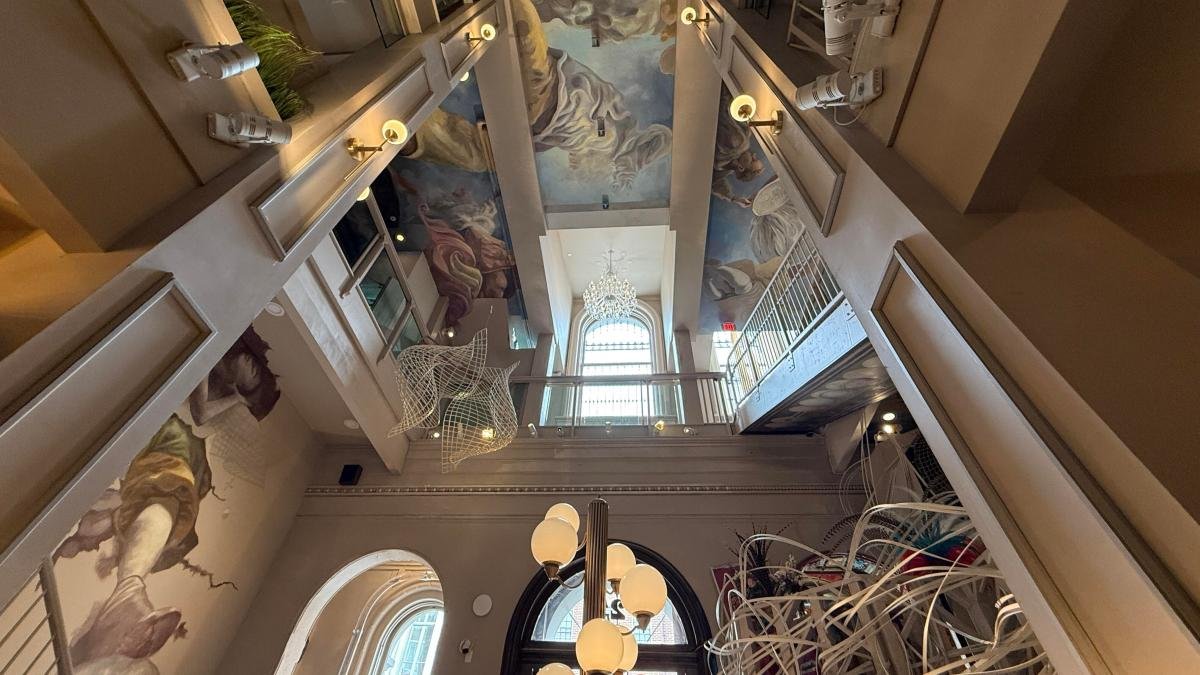 A vaulted ceiling in a lobby with art and windows for Ministry of Awe in Philadelphia.