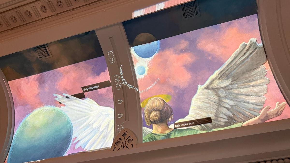 A mural with an angel and words highlighting parts of the painting.