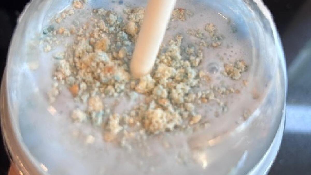 light blue milkshake with crumbs in a cup